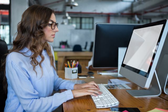 Graphic designer working over computer at desk in office
