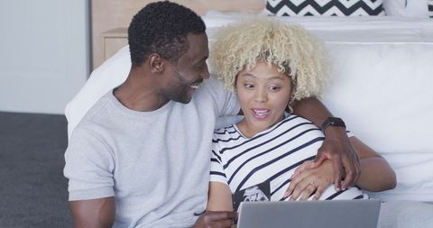 Expectant couple viewing ultrasound with excitement at home