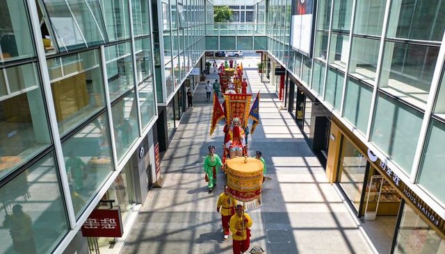 Colorful chinese festival procession marching through modern glass shopping arcade