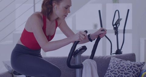 Focused Woman Exercising at Home on Stationary Bike