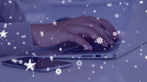 Hands Typing on Laptop with Snow Falling Effects