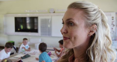 Thoughtful Teacher Overseeing Diverse Classroom Activities