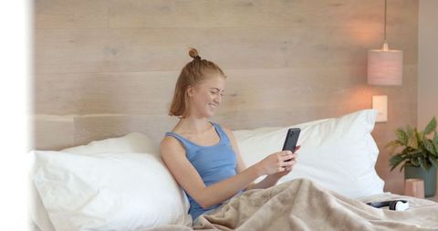 Relaxed Woman in Bedroom Using Smartphone Comfortably