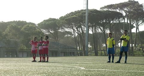 Soccer players gearing up on sunlit field for competitive match
