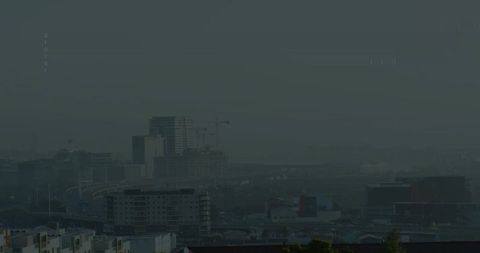 Foggy Urban Skyline with Construction Cranes Looming