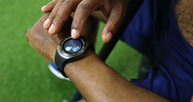 Close-up of person interacting with fitness tracking features on smartwatch in outdoor setting. Ideal for use in articles or advertisements about wearable technology, fitness gadgets, health monitoring, or outdoor activities.