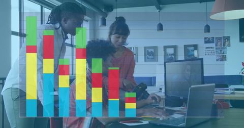 multinational colleagues concentrating on business strategies with colorful bar graphs overlaying them in a modern office. image conveys concepts of teamwork, diversity in the workplace, data-driven decision making, and digital transformation. useful for articles on inclusive work culture, technology in business, and visual storytelling in corporate communication.