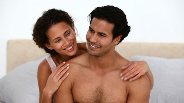 A happy couple hugging in a cozy bedroom, showing love and connection. Ideal for use in advertisements, promotions for romantic getaways, relationship counseling, and lifestyle blogs focusing on love and intimacy.