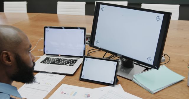 Businessman working on multiple devices in conference room - Download Free Stock Images Pikwizard.com