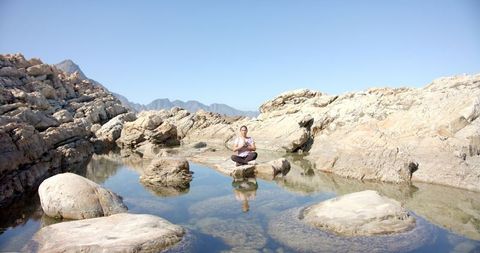 Woman Meditating on Rocks in Tranquil Mountain Landscape - Download Free Stock Images Pikwizard.com