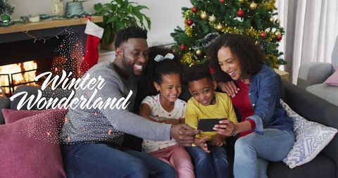 Joyful Family Celebrating Christmas by Fireplace with Digital Interface