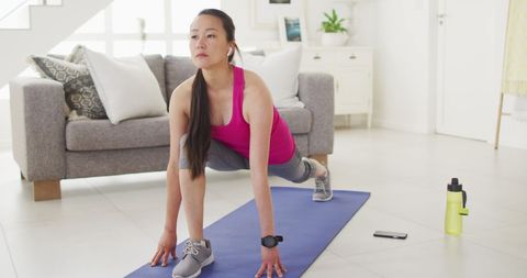 Asian Woman Exercising at Home on Yoga Mat