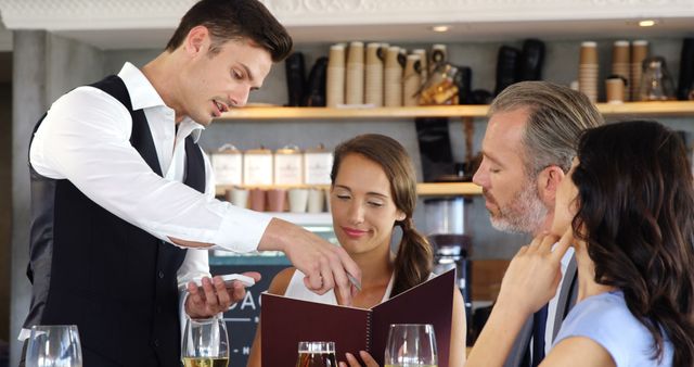 Waiter suggesting the menu to three people at restaurant 