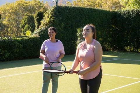Two Women Playing Tennis on Outdoor Court