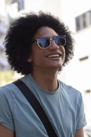 African american man smiling in sunglasses with city reflections casual street portrait