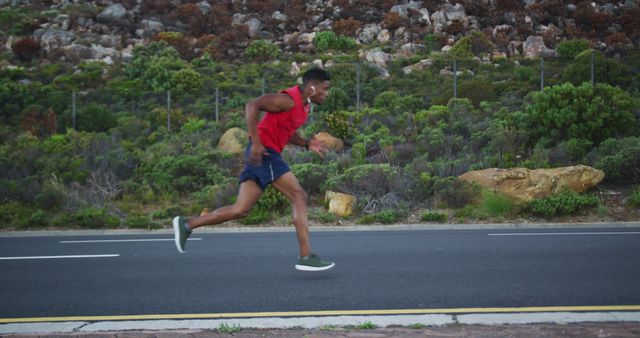 Man running on mountain road, embodying fitness and active lifestyle. Ideal for content related to health, exercise, motivation, and the benefits of outdoor activities. Can be used in articles, blog posts, advertisements or social media campaigns focused on physical fitness and well-being.
