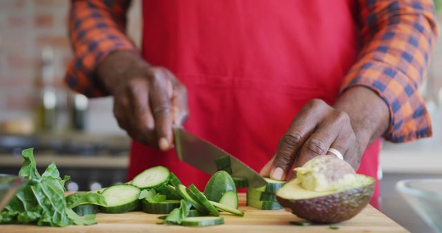 Man in Red Apron Slicing Fresh Vegetables in Kitchen - Download Free Stock Images Pikwizard.com