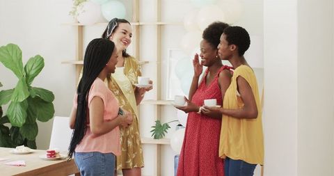 Women Enjoying Tea and Conversation Indoors Celebrating Friendship