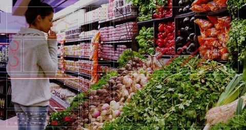 Woman shopping for fresh vegetables in supermarket aisle