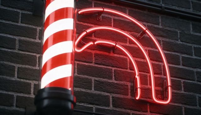Glowing barber pole with red neon arcs casting warm light on textured brick wall exterior