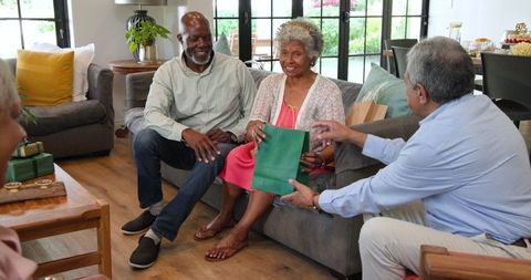 Senior friends celebrating birthday with gift exchange