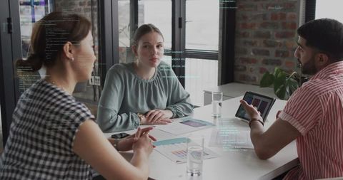 Creative team collaborating around table with woman listening and reviewing color charts