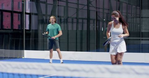 Competitive match on glass paddle tennis court