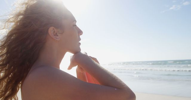 Serene Woman Holding Surfboard at Sunny Beach - Download Free Stock Images Pikwizard.com