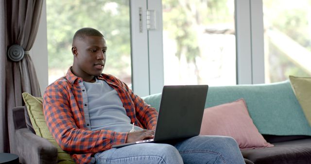 Young Man Working Remotely on Laptop in Relaxed Home Environment - Download Free Stock Images Pikwizard.com