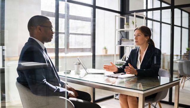 Executive discussion showing manager explaining strategy and listening in modern glass corporate off