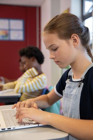 Youth Engaging with Technology in Bright Classroom Environment