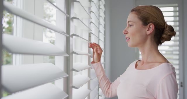 Woman Looking Through Window Blinds in Bright Modern Home - Download Free Stock Images Pikwizard.com