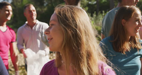 Diverse Volunteers Engaged in River Cleanup on Sunny Day