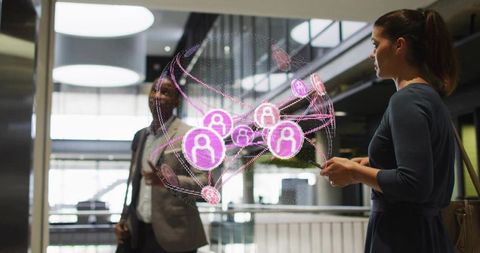 Professionals interacting with augmented reality social network hologram in office atrium