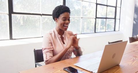 African American Woman Engaged in Virtual Meeting at Office Desk