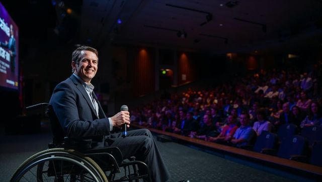 Inspirational speaker in wheelchair engaging audience at conference