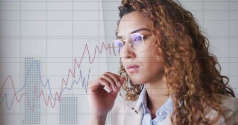 Businesswoman Analyzing Financial Graph Data in Modern Office