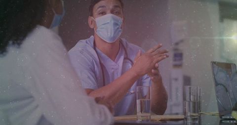 Masked Medical Professional in Discussion at Clinic Desk