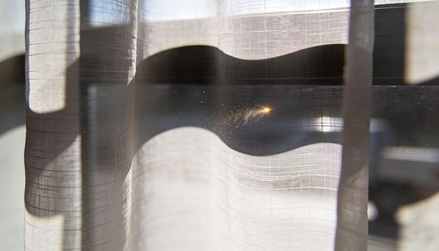 Glowing sheer curtain filtering layered sunlight with dust sparkle and soft folds
