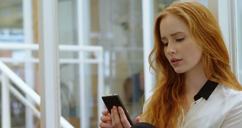 Young Woman Focusing on Smartphone in Office Environment - Download Free Stock Images Pikwizard.com