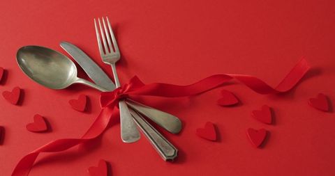 Table Setting with Cutlery Tied in Red Ribbon Surrounded by Hearts on Red Background - Download Free Stock Images Pikwizard.com