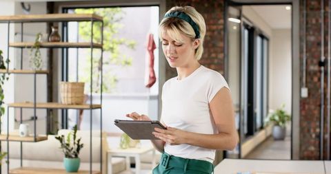 Woman Using Tablet in Contemporary Loft Office Environment
