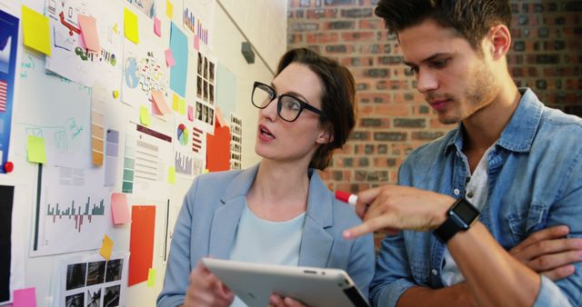 Creative professionals in a modern office working on a project together. Ideal for concepts of teamwork, innovation, project management, and office culture.