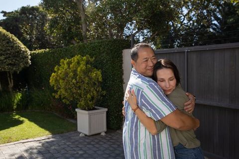 Couple Embracing on Sunny Patio with Garden View