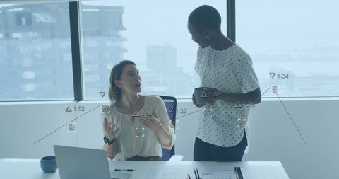 Businesswomen Collaborating with Financial Analytics in Modern Office