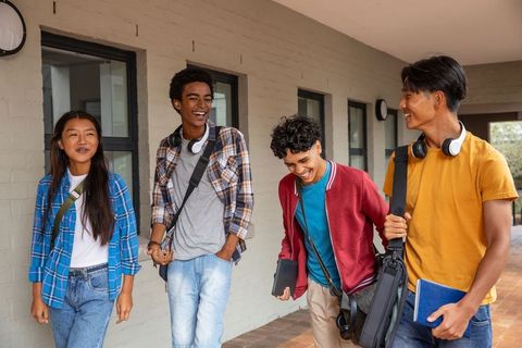 Diverse Group of Friends Walking with School Supplies Smiling Outdoors