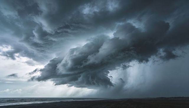 Menacing coastal storm gathering over dark sea with dramatic rain shafts and shelf cloud