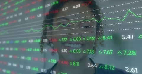 Smiling financial analyst viewing rising stock market data overlay on office glass display