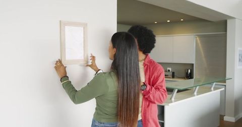 Couple decorating home with picture frame in minimalist kitchen