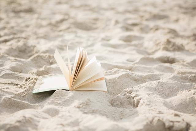 Open book on sand at beach